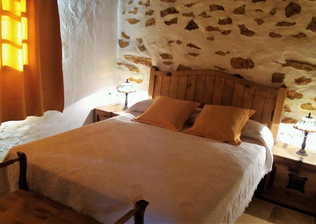 a bedroom with a large bed with two night stands at Casa antigua en el centro de Fuerteventura in Antigua