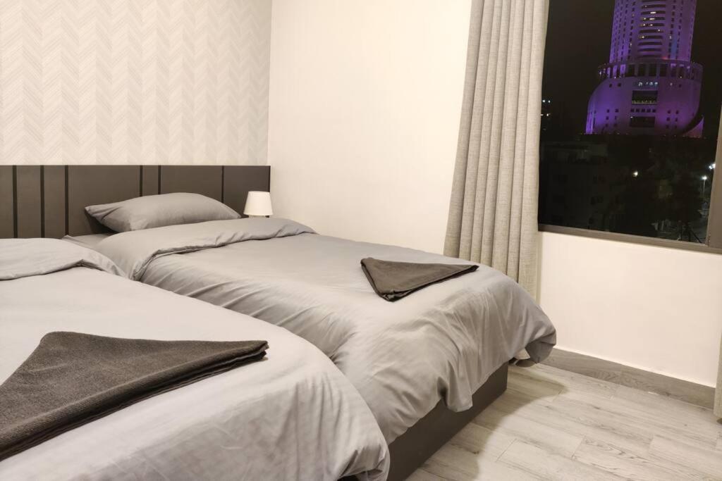 2 łóżka w sypialni z widokiem na budynek w obiekcie 46m luxury room near downtown and all services w mieście Amman