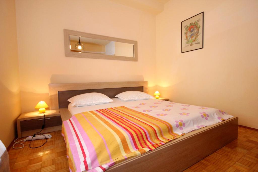ein Schlafzimmer mit einem Bett mit einer bunten Decke darauf in der Unterkunft Apartments with WiFi Dubrovnik - 4681 in Dubrovnik