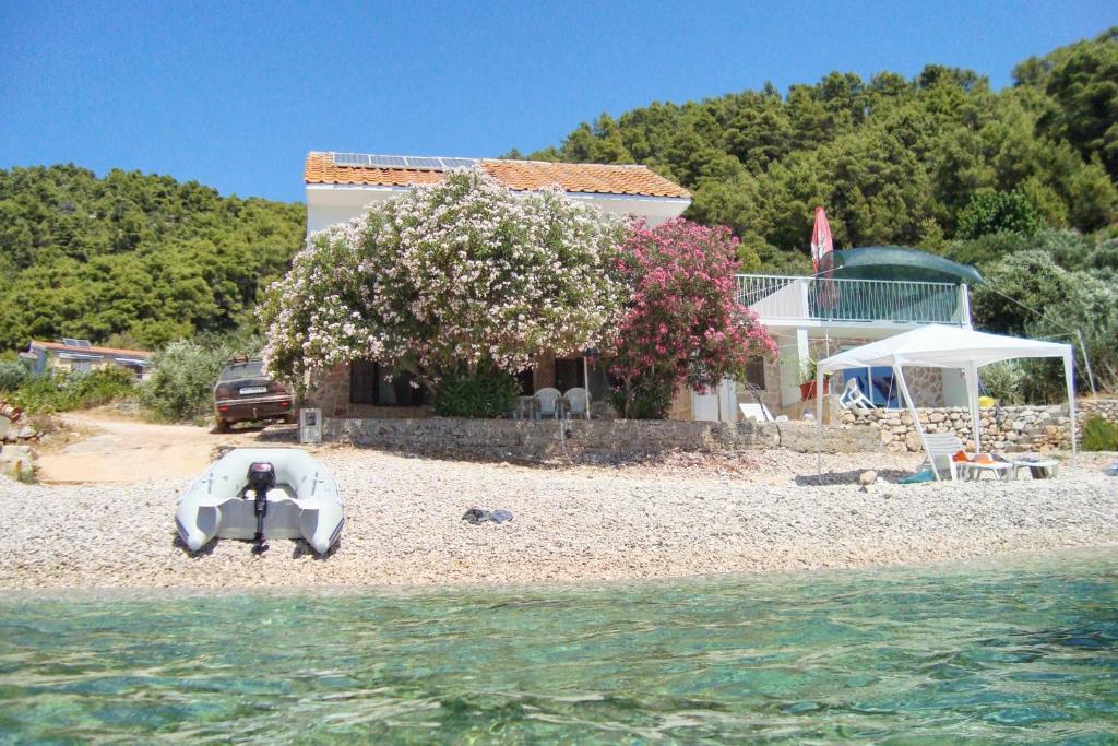 una casa sulla spiaggia con una barca sulla riva di Seaside secluded apartments Cove Skozanje, Hvar - 4624 a Gdinj