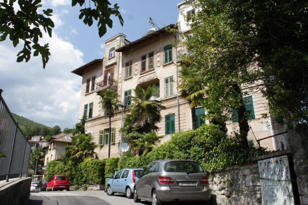 a building with cars parked in front of it at Apartments with a parking space Opatija - 3436 in Opatija