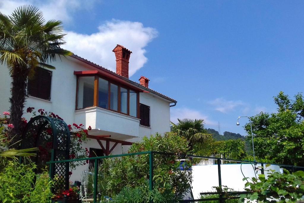 Veprinac的住宿－Family friendly house with a swimming pool Veprinac, Opatija - 3447，白色的房子,设有窗户和围栏
