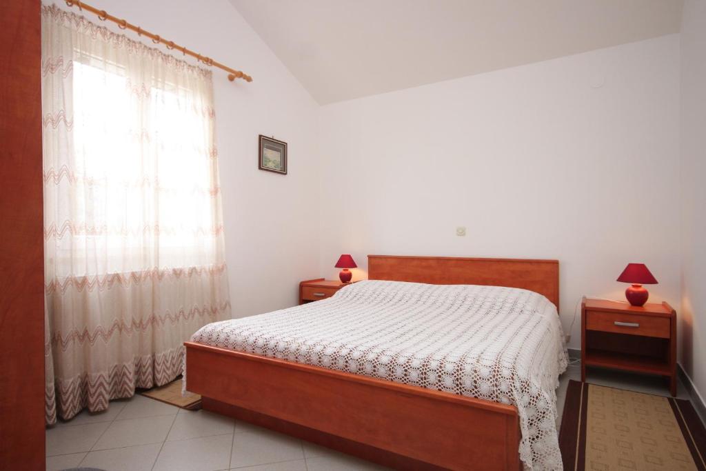 a bedroom with a bed and a window at Apartment Nerezine 3451c in Nerezine
