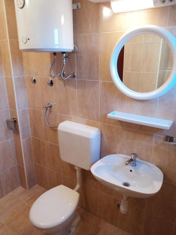 a bathroom with a toilet and a sink and a mirror at Apartments with a parking space Podaca, Makarska - 4747 in Podaca