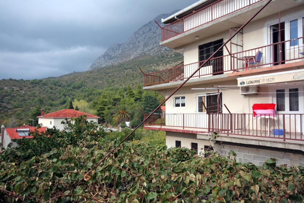 a building on a hill with a mountain in the background at Apartments with a parking space Podaca, Makarska - 4747 in Podaca
