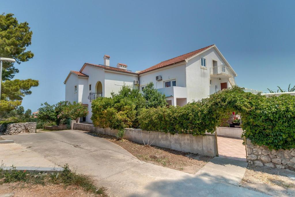 a large white house with a stone wall at Double Room Mali Losinj 3445h in Mali Lošinj