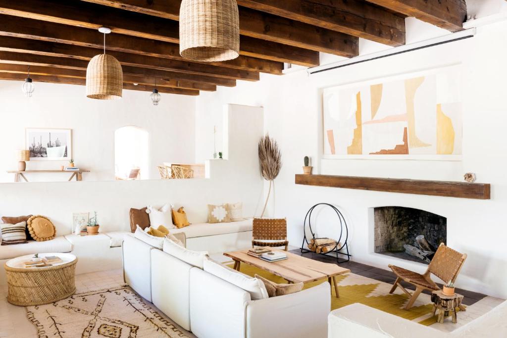 a living room with white furniture and a fireplace at The JTH Tucson in Tucson