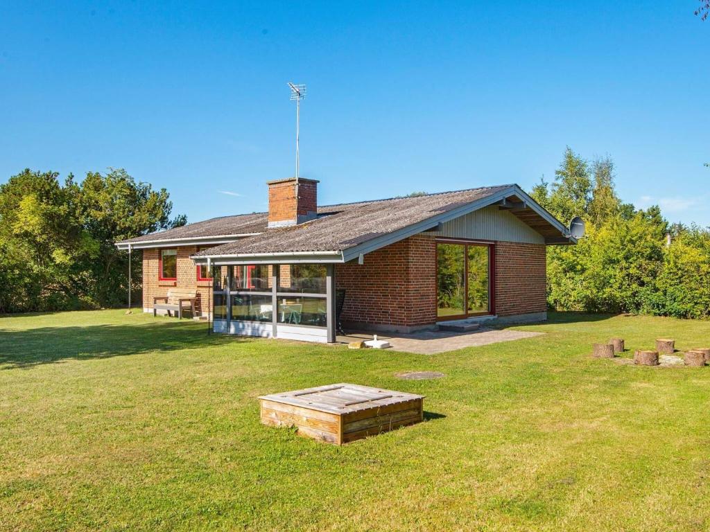a brick house with a large yard in front of it at Holiday Home Strandskadevej in Ørsted