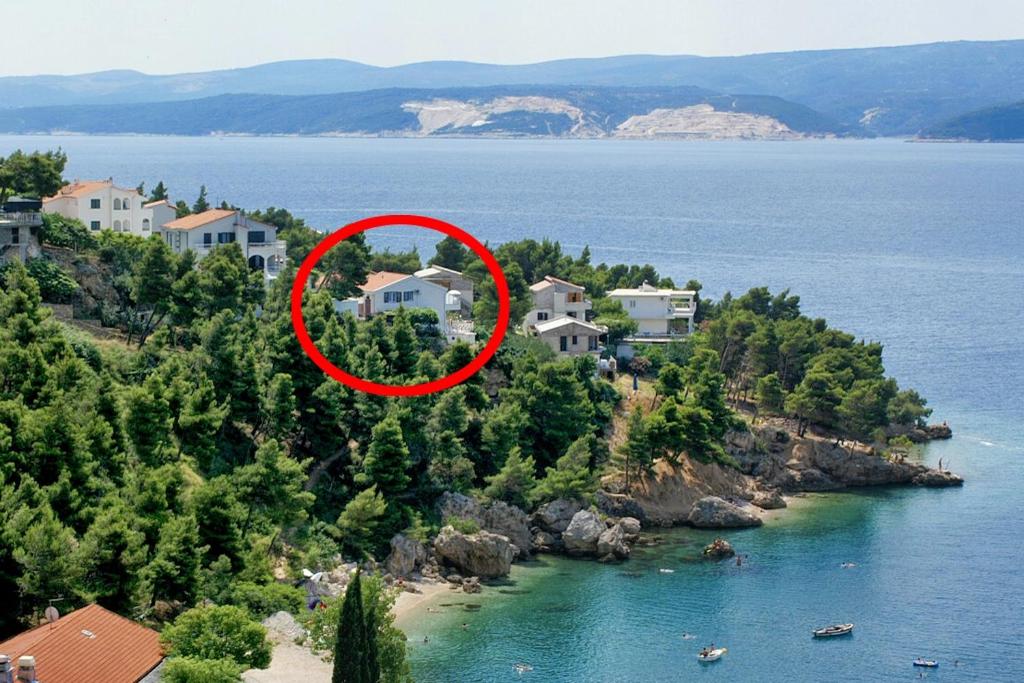 a house on an island in the water at Apartments by the sea Balica Rat, Omis - 2753 in Tice