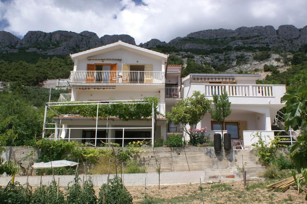 ピサックにあるApartments by the sea Pisak, Omis - 2750の山を背景にした家