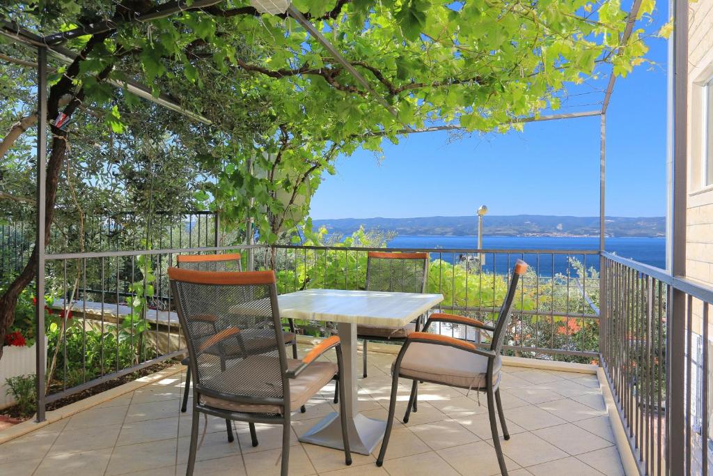 a table and chairs on a patio with a view of the water at Apartments by the sea Duce, Omis - 2737 in Duće