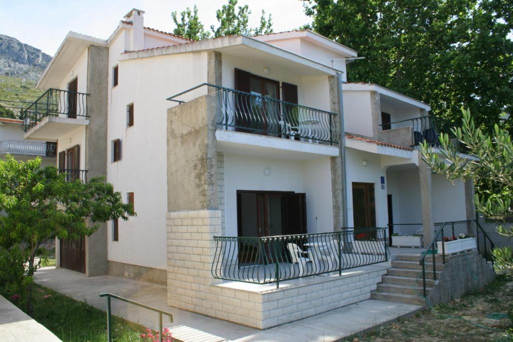 a house with balconies on the side of it at Apartments and rooms by the sea Duce, Omis - 2746 in Duće
