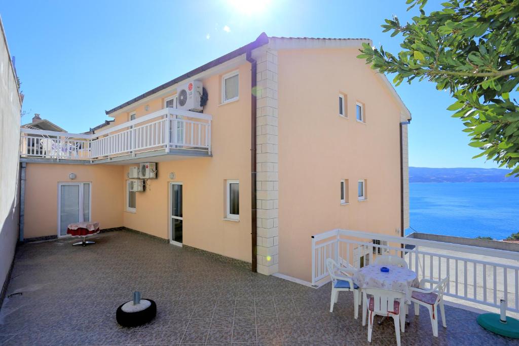 a balcony of a house with a table and chairs at Apartments with parking space Stanici, Omis - 2818 in Tice