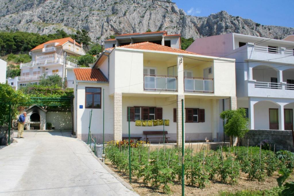 uma casa branca com uma montanha ao fundo em Apartments with a parking space Omis - 2751 em Omiš