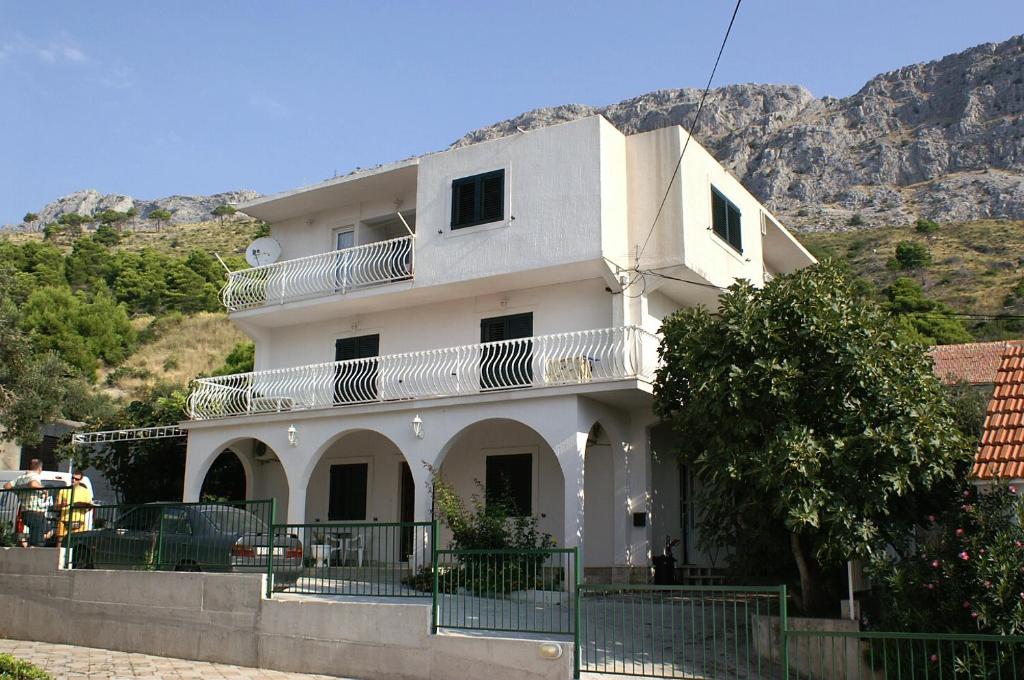 een wit huis aan de kant van een berg bij Apartments with a parking space Duce, Omis - 2801 in Omiš