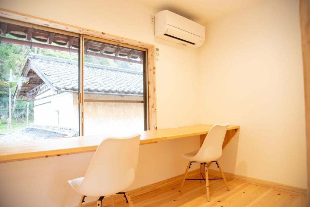 長浜市にあるWorcation base Kaminyu Yamane House - Vacation STAY 03960vの椅子2脚、デスク、窓が備わる客室です。