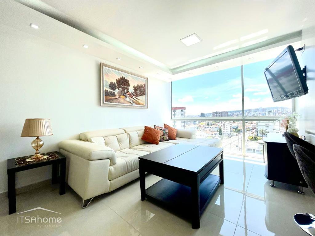 sala de estar con sofá blanco y TV en ItsaHome Apartments - Torre Seis, en Quito
