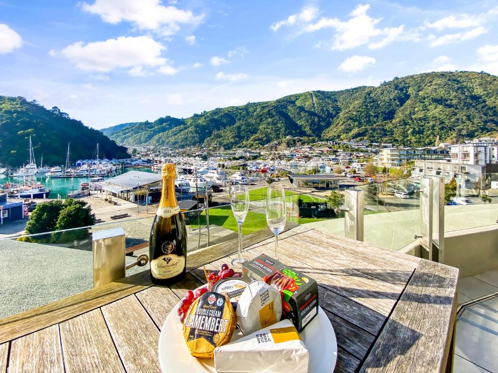 a table with a bottle of wine and snacks on a balcony at Two Bedroom Apartment on the water in Picton