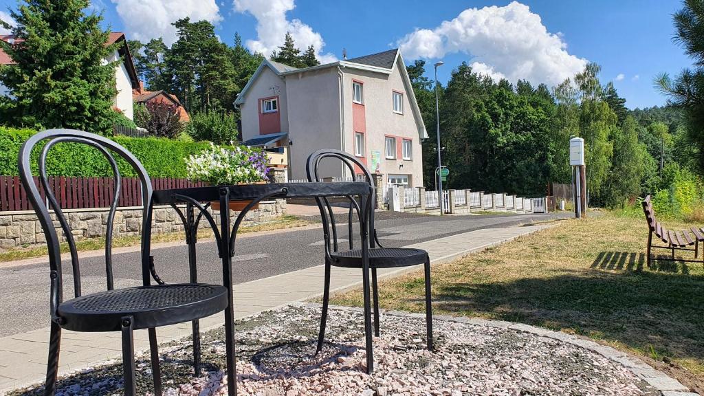 ein Tisch und zwei Stühle auf einer Straße in der Unterkunft Penzion Prachov in Jičín