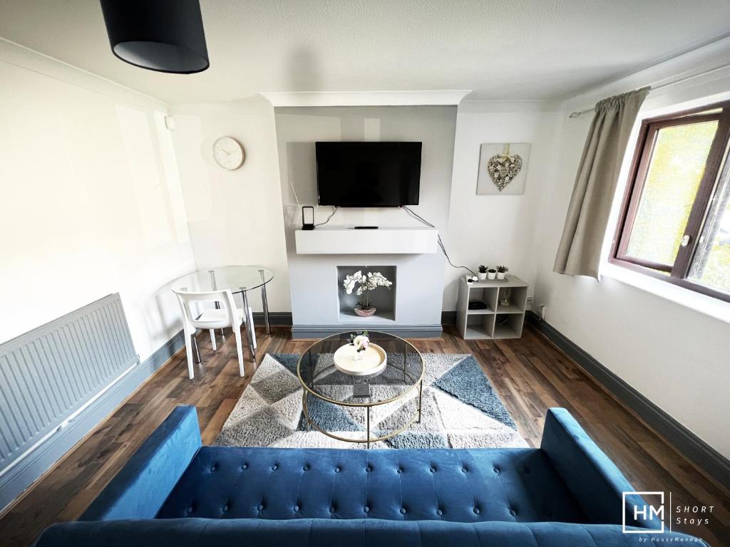 a living room with a blue couch and a table at Enfield House - Beautiful 2 Bed - Good Transport Free Parking in Enfield Lock
