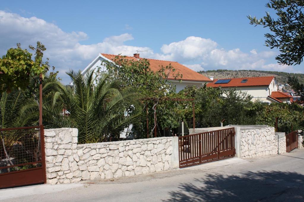 a stone fence in front of a house at Apartments with a parking space Businci, Ciovo - 4667 in Trogir