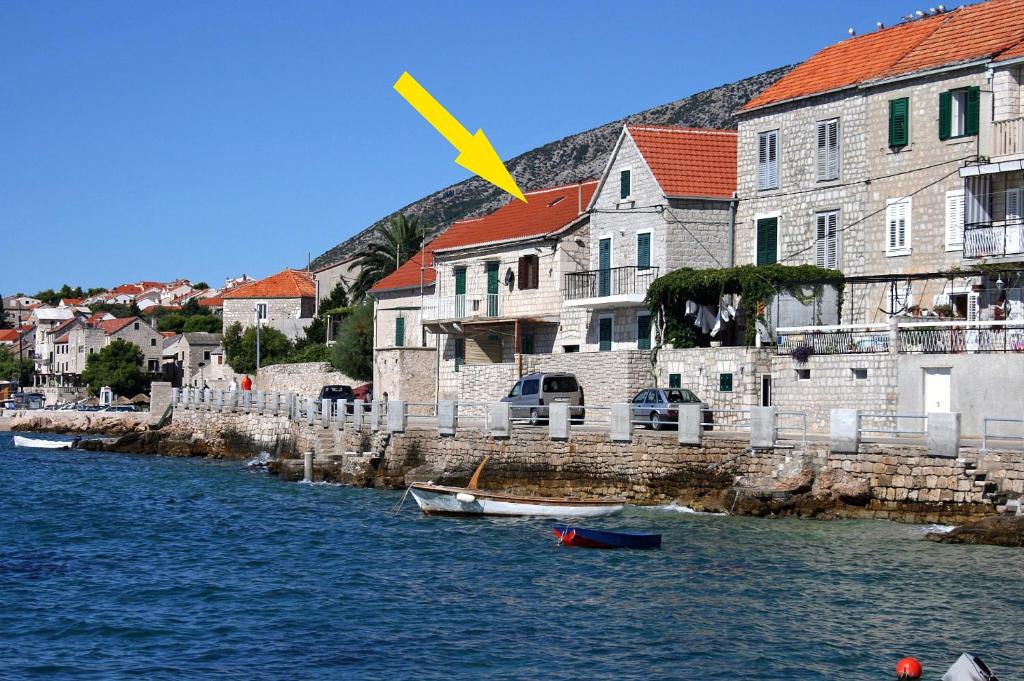 a group of buildings next to a river with boats at Apartments by the sea Bol, Brac - 4657 in Bol