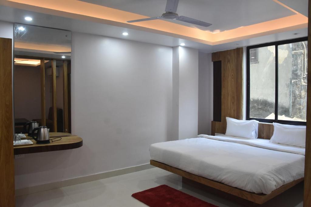 um quarto com uma cama grande e uma janela em Hotel Crown Palace em Patna