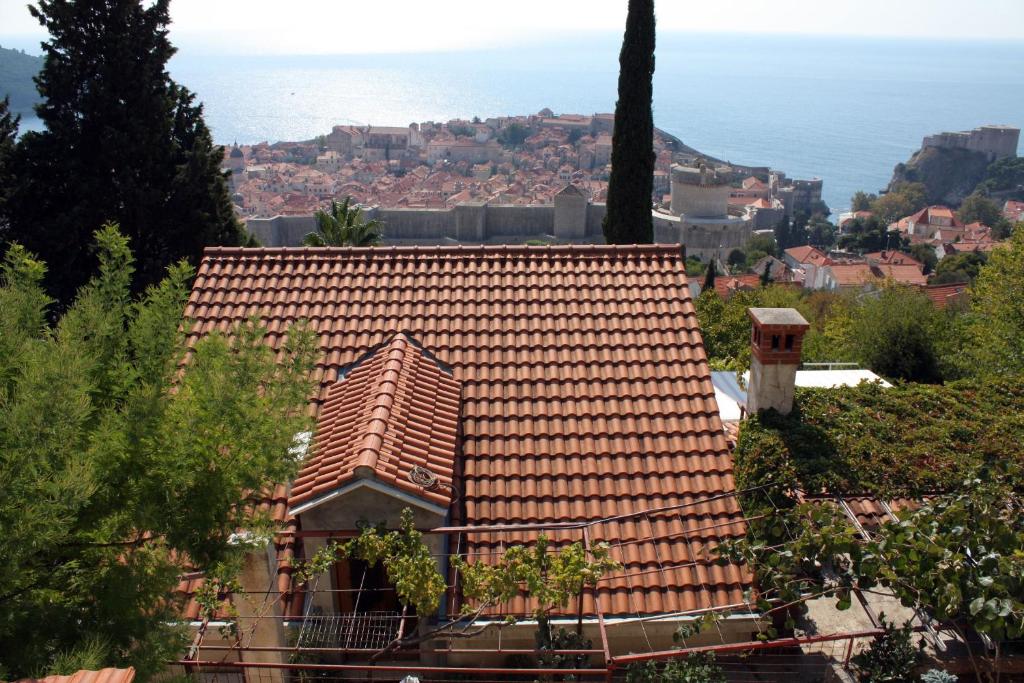 una casa con un tetto di tegole rosse su una collina di Apartments with a parking space Dubrovnik - 4673 a Dubrovnik