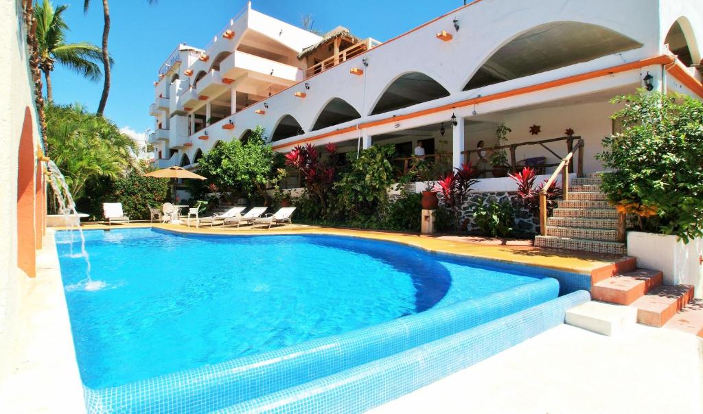 a swimming pool in front of a building at Hotel Casa Sun and Moon in Zihuatanejo