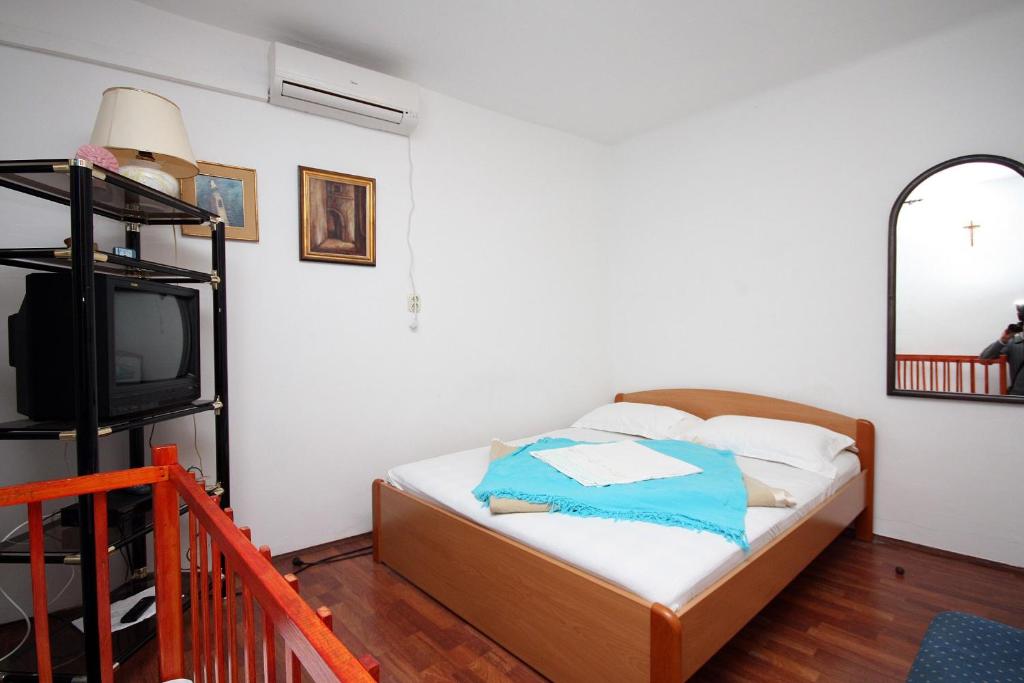 1 dormitorio pequeño con 1 cama y TV en Apartments by the sea Dubrovnik - 4698, en Dubrovnik