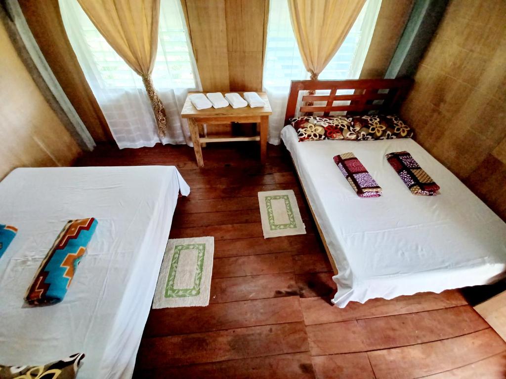 Habitación con 2 camas y mesa. en Batad Countryside, en Banaue