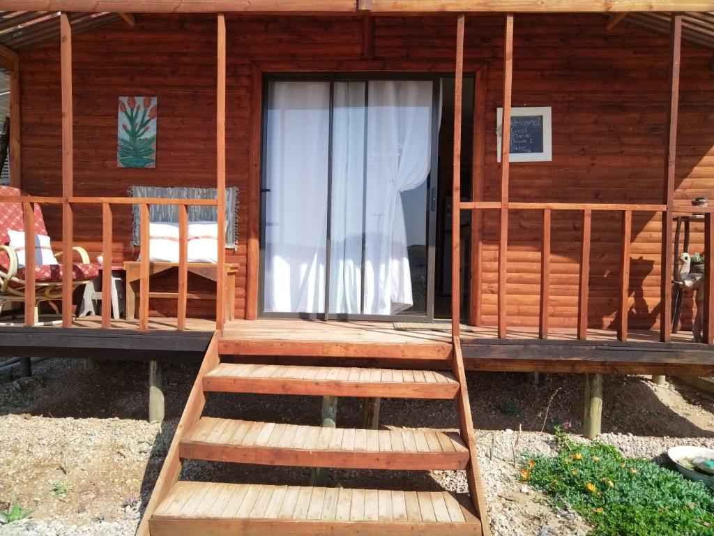 a wooden cabin with stairs leading to the door at Mai lo stesso in Kakamas