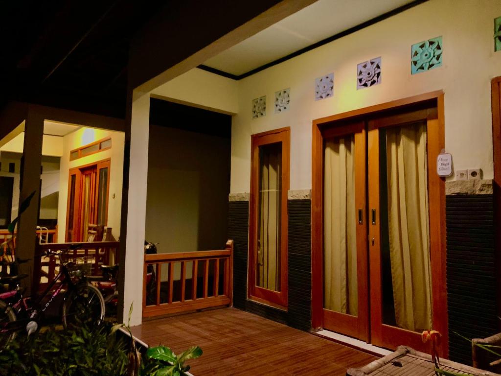 a porch of a house with wooden doors at Anugrah Bungallow in Gili Islands