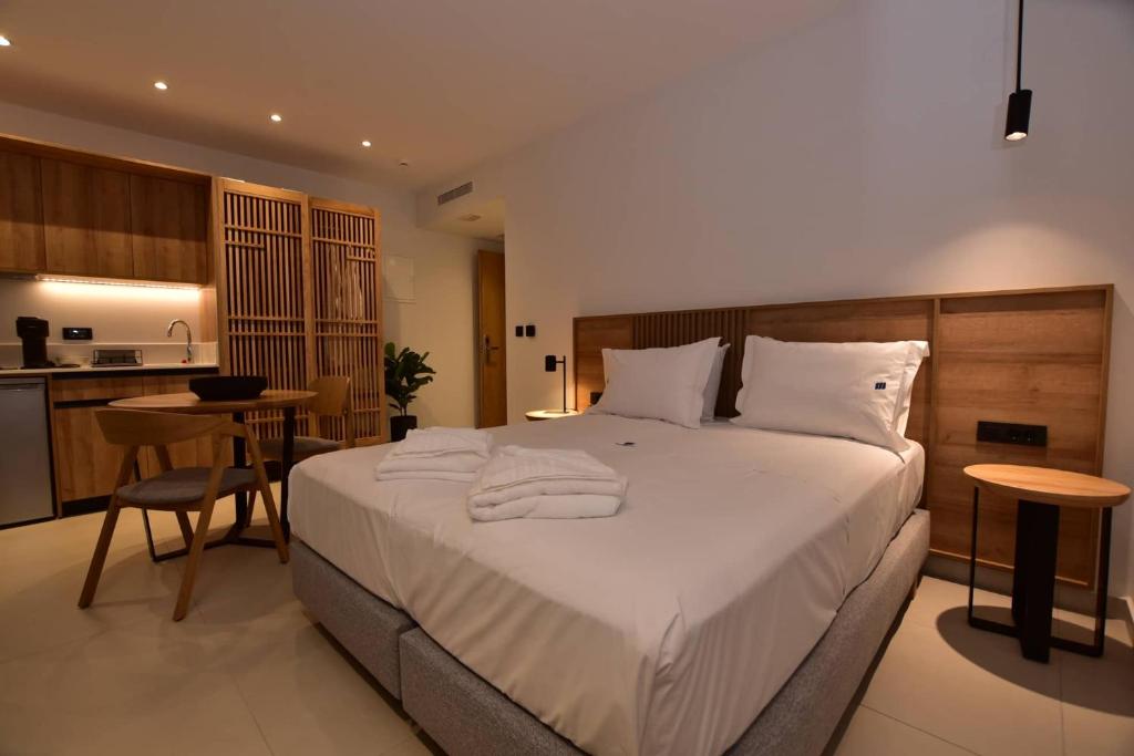 a bedroom with a large white bed and a kitchen at Mediterranean Dream in Palaiochora