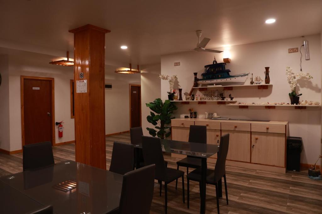 a kitchen and dining room with a table and chairs at Cowry Inn in Fulidhoo