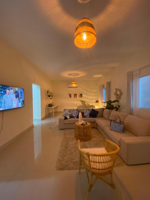 a living room with a couch and a tv at Bohemian beach house in Abū az̧ Z̧ulūf