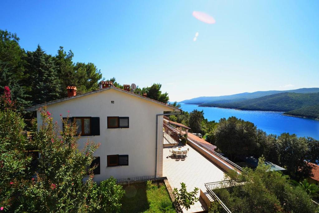 a white house with a view of a lake at Apartments with parking space Rabac, Labin - 3011 in Rabac