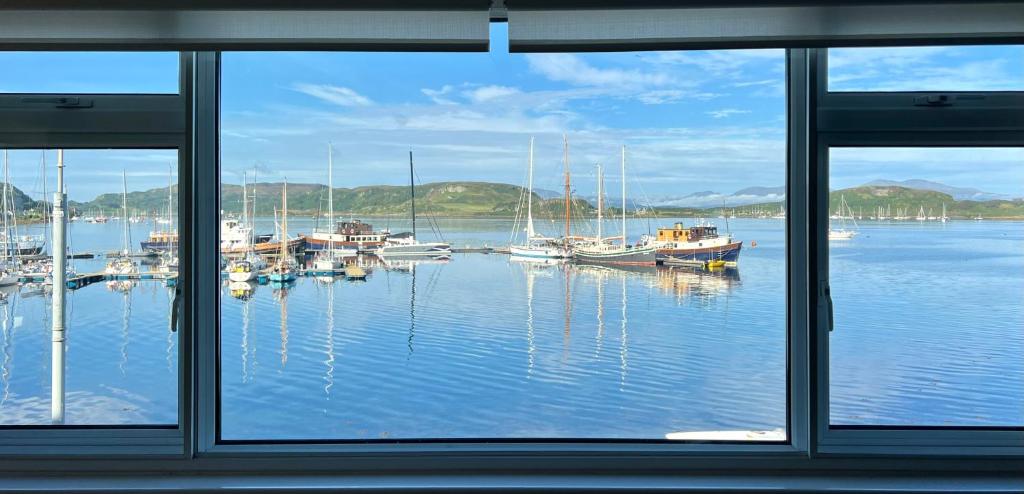 a view from a window of a harbor with boats at Island View in Oban