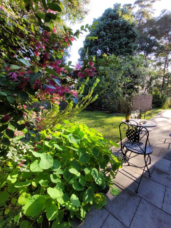 um jardim com mesa, cadeiras e flores em Garden Rest em New Lambton