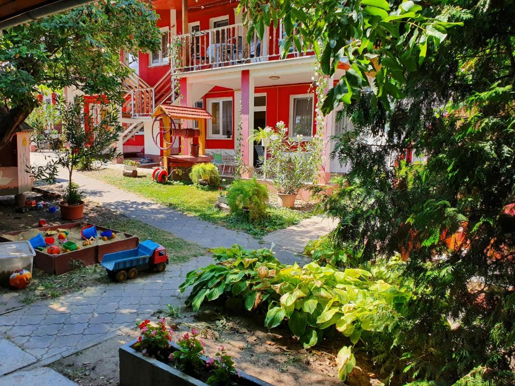 um jardim em frente a uma casa vermelha e branca em Apartmány Viola em Štúrovo