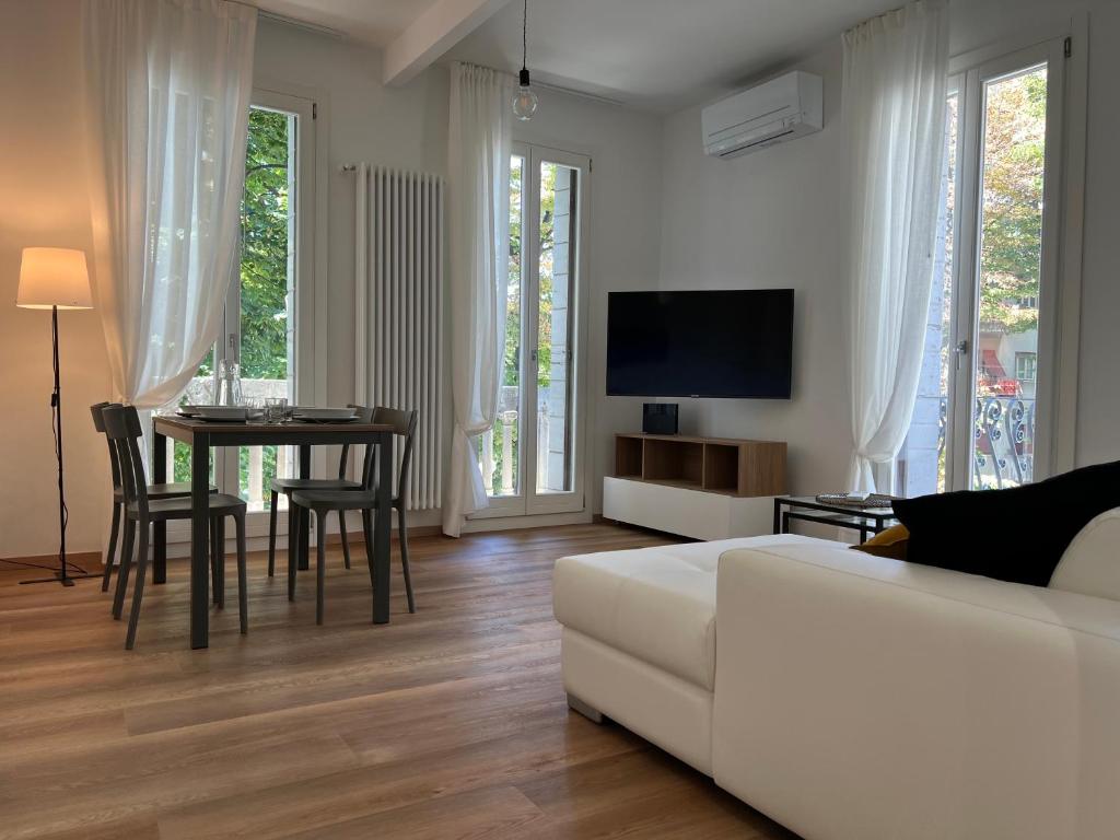 a living room with a white couch and a table at Ca' Luciano alloggio a Lido di Venezia in Venice-Lido