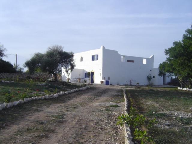 a dirt road in front of a white building at RIAD ACACIA in Essaouira