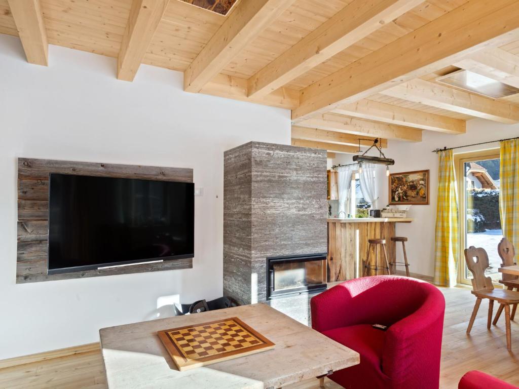 a living room with a table and a tv at Cozy holiday home with sauna in Sankt Margarethen in Sankt Margarethen im Lungau
