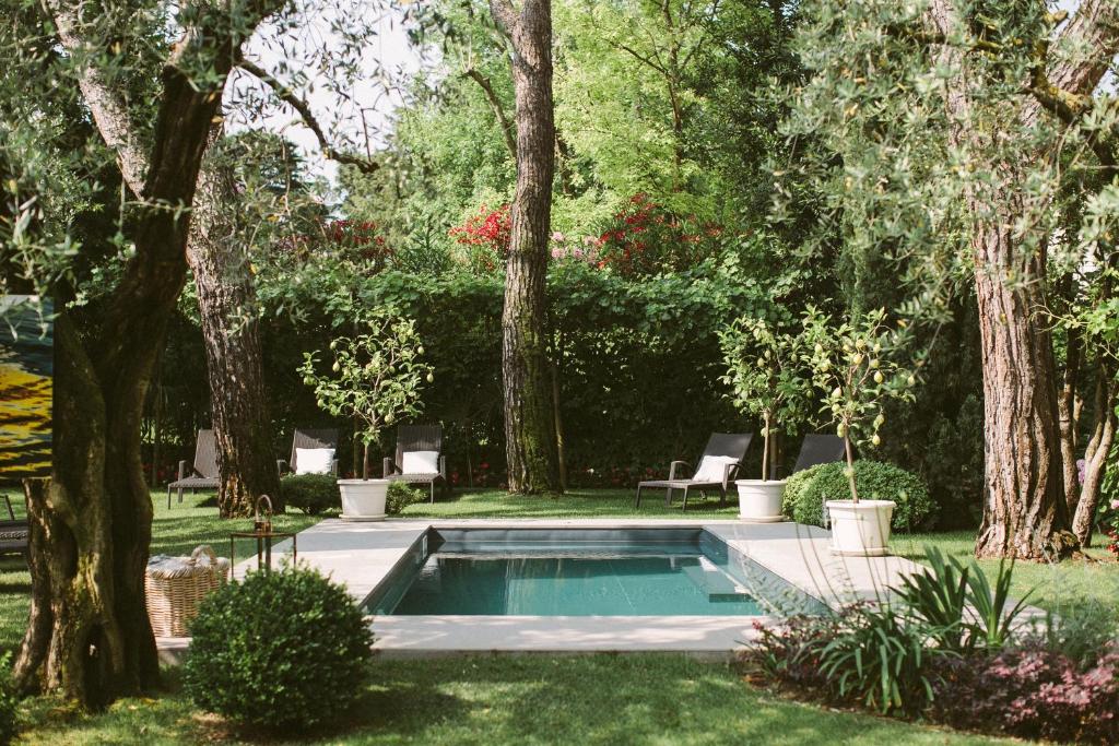 a swimming pool in a yard with trees at Hotel Piccola Vela in Desenzano del Garda