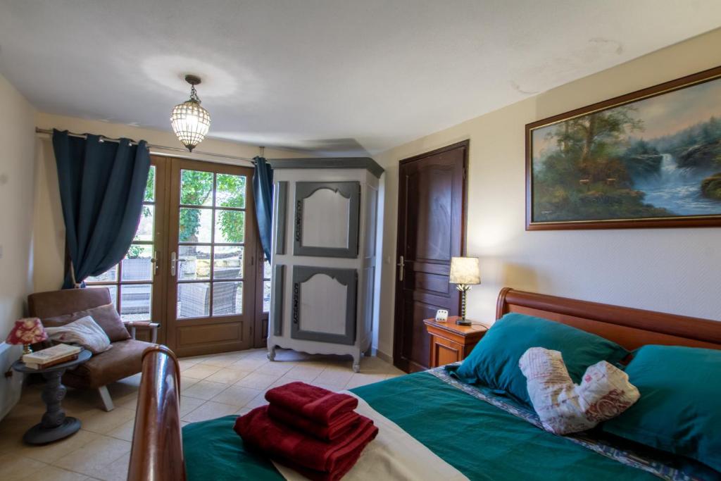 sypialnia z łóżkiem, krzesłem i oknem w obiekcie le petit gite Maison Croix du Sud w mieście Saint-Amand-de-Vergt