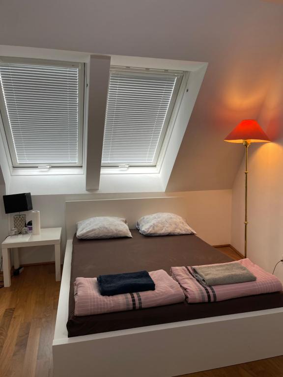 1 dormitorio con 1 cama grande y 2 ventanas en Rooftop Room 2 en Viena
