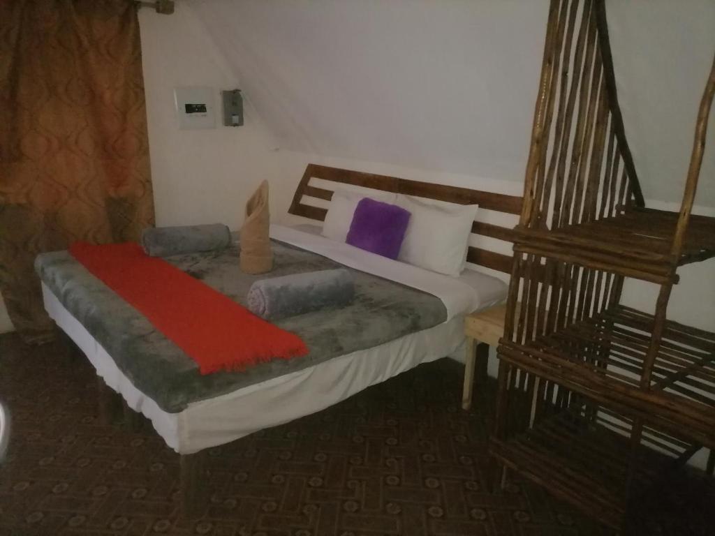 Un dormitorio con una cama con una manta roja. en Sabs Cottage, en Kasane