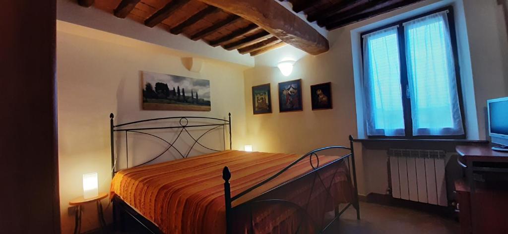 1 dormitorio con 1 cama, TV y ventana en COR MAGIS KAMULLIA - 200 meters from the historic center and close to the train station, en Siena