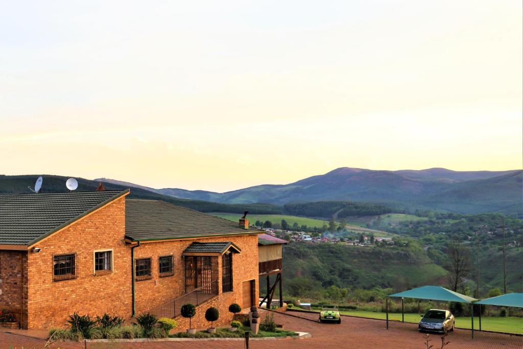 een stenen huis met uitzicht op de bergen bij Waterval Self-Catering Holiday Home in Sabie