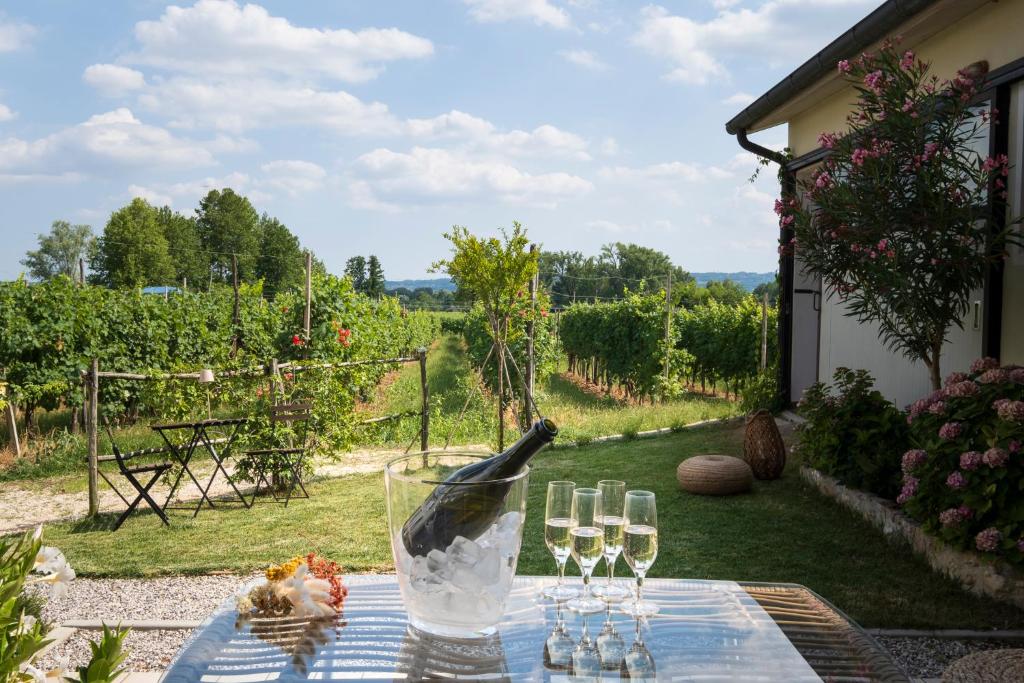 - une table avec des verres à vin et un oiseau assis dans l'établissement Le Vigne del Gallo, à Farra di Soligo